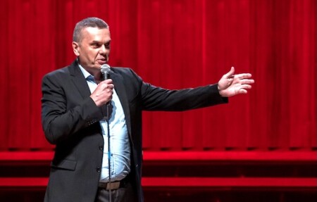 Saša Turković, etwas näher fotografiert. Der Kittel ist offen, er streckt den einen Arm auf die Seite.